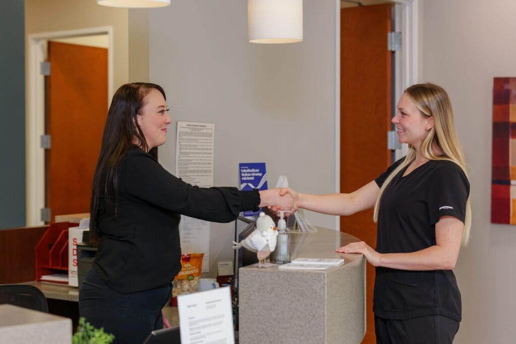 Dental staff shaking hands in a clinic setting
